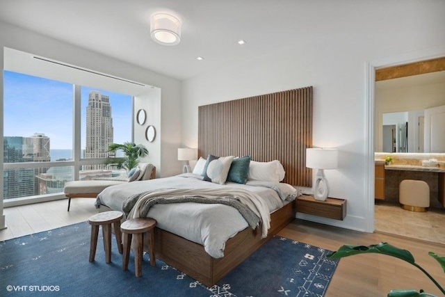 bedroom featuring a view of city and wood finished floors