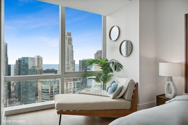 interior space with a view of city, floor to ceiling windows, and wood finished floors