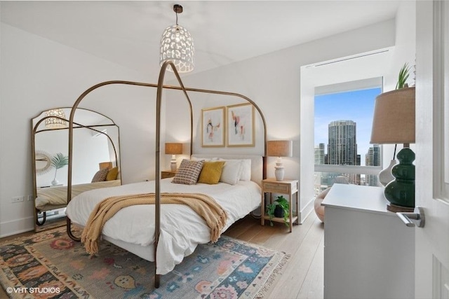 bedroom with wood finished floors and a city view