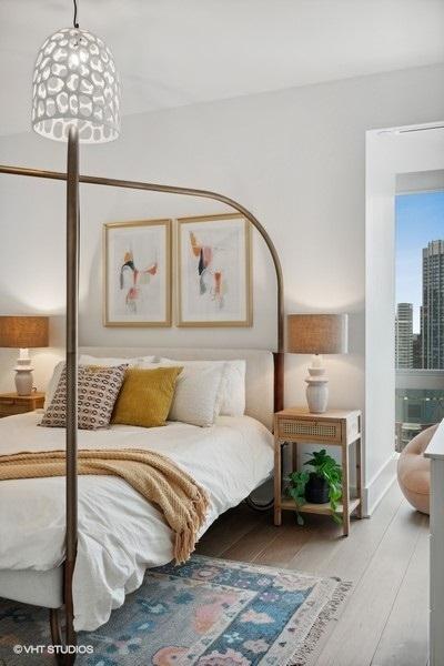 bedroom with light wood finished floors and a city view