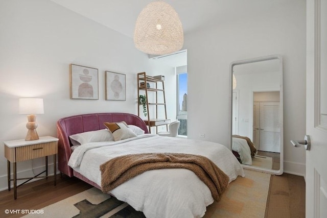 bedroom with baseboards and wood finished floors