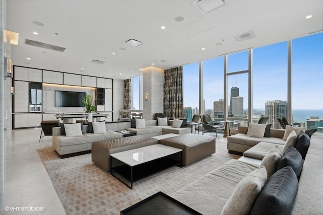 living room with a wall of windows, a view of city, visible vents, and light tile patterned flooring