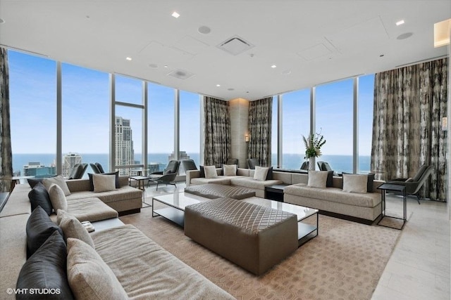 living room with a wall of windows, visible vents, and a water view