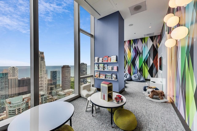 game room with a wall of windows, carpet, plenty of natural light, and a view of city