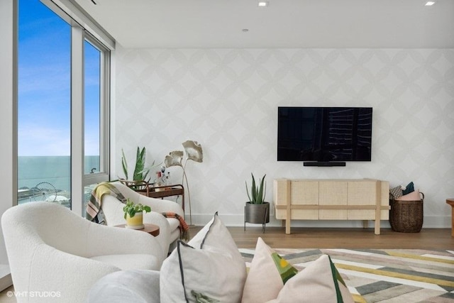 living room featuring wood finished floors, plenty of natural light, baseboards, and wallpapered walls