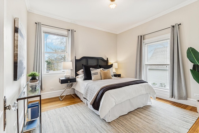 bedroom with baseboards, ornamental molding, and wood finished floors