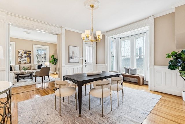 dining area with a wealth of natural light, ornamental molding, and a chandelier