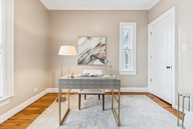 office space featuring baseboards, ornamental molding, and wood finished floors