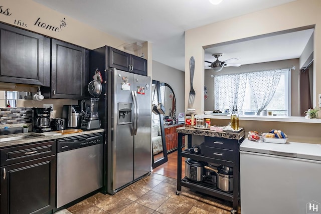 kitchen with light countertops, appliances with stainless steel finishes, a sink, and a ceiling fan