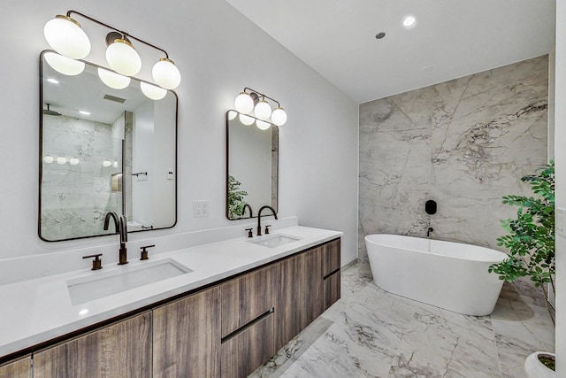 bathroom with a sink, a freestanding tub, a stall shower, and marble finish floor