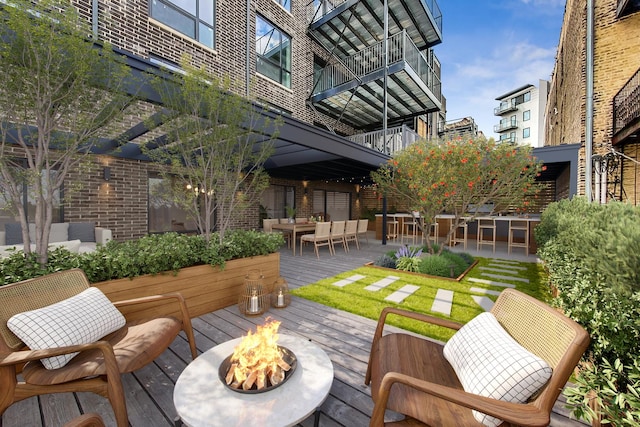 exterior space featuring a wooden deck and a fire pit