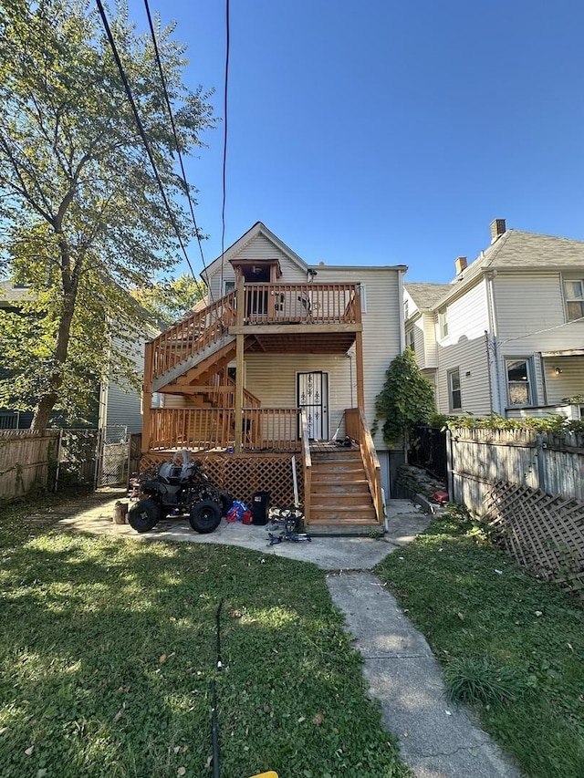 back of property with a wooden deck, stairs, fence, and a yard