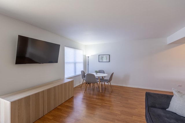 dining room with baseboards and light wood-style flooring