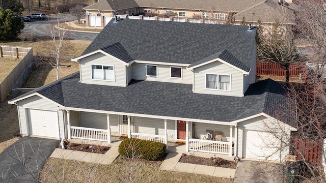 view of front of house featuring covered porch, driveway, and a shingled roof