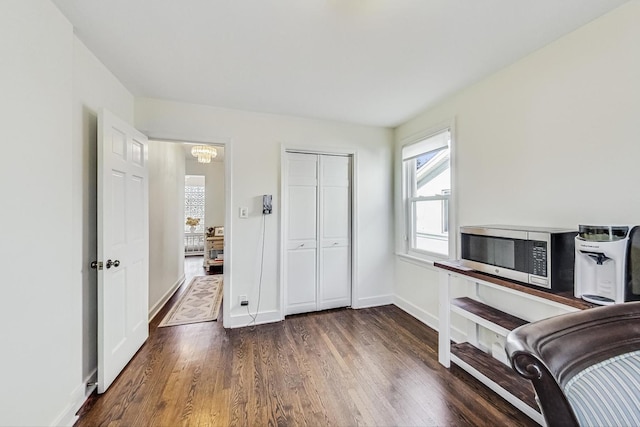 bedroom featuring a closet, baseboards, and dark wood-type flooring