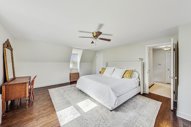 bedroom with baseboards, ceiling fan, dark wood-style flooring, and vaulted ceiling