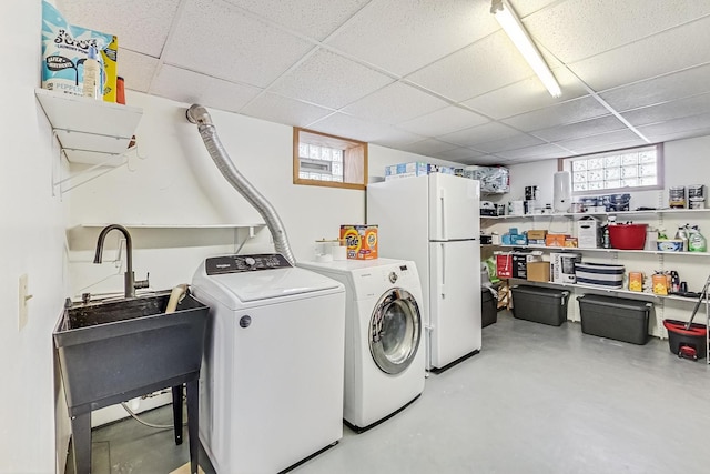 laundry area with laundry area, washing machine and dryer, and a sink