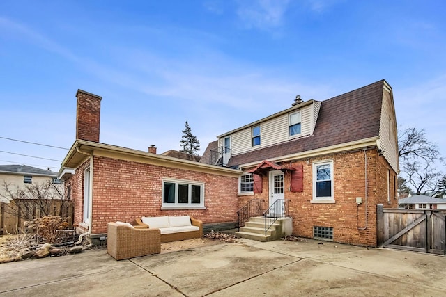 back of house featuring outdoor lounge area, a patio, brick siding, and a chimney