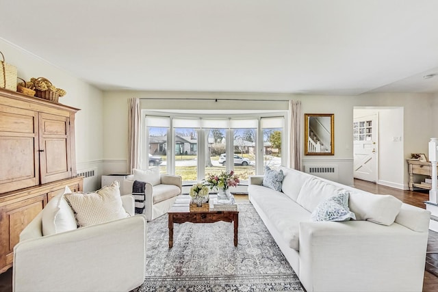 living area featuring dark wood finished floors, radiator heating unit, and baseboards