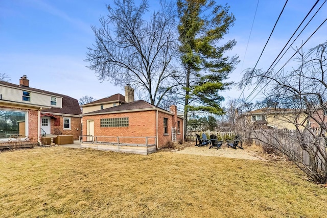 back of property with entry steps, a yard, a fenced backyard, and brick siding