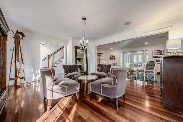 living area with a notable chandelier, stairway, dark wood-type flooring, and ornamental molding