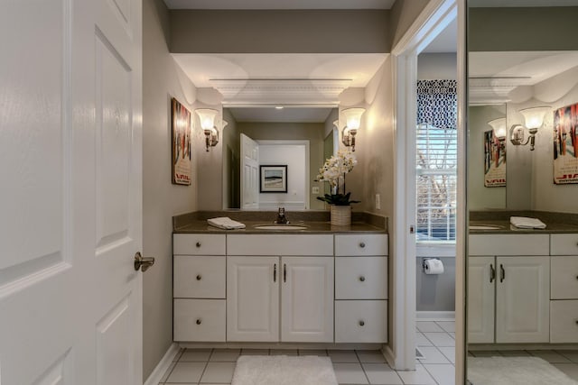 bathroom with vanity, baseboards, and tile patterned flooring