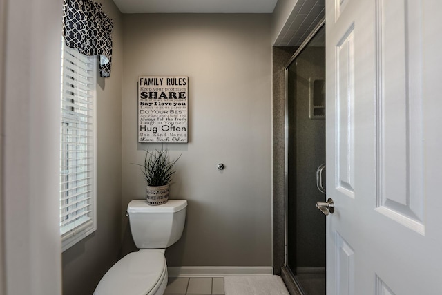 full bathroom with baseboards, plenty of natural light, toilet, and a stall shower