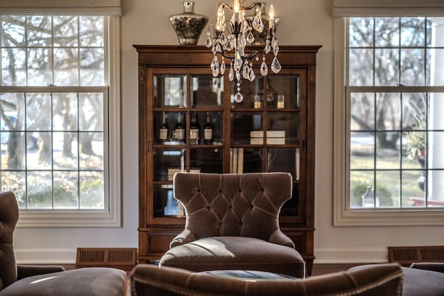 sitting room featuring a notable chandelier, baseboards, and visible vents