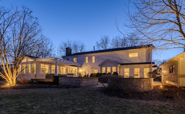 rear view of house with a lawn, a patio area, a pergola, and a chimney