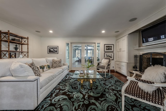 living area featuring dark wood-style floors, a fireplace with raised hearth, french doors, and crown molding