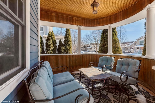 sunroom / solarium with plenty of natural light, wood ceiling, and decorative columns