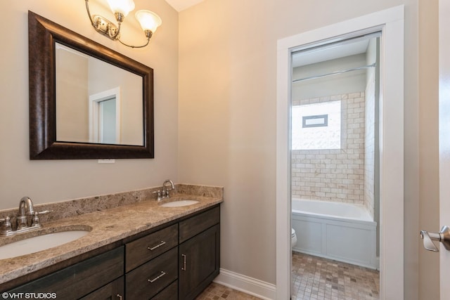 full bath with baseboards, a sink, toilet, and double vanity