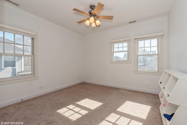 unfurnished room featuring baseboards, visible vents, ceiling fan, and carpet flooring