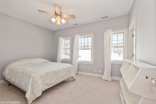 bedroom featuring baseboards, ceiling fan, visible vents, and light colored carpet