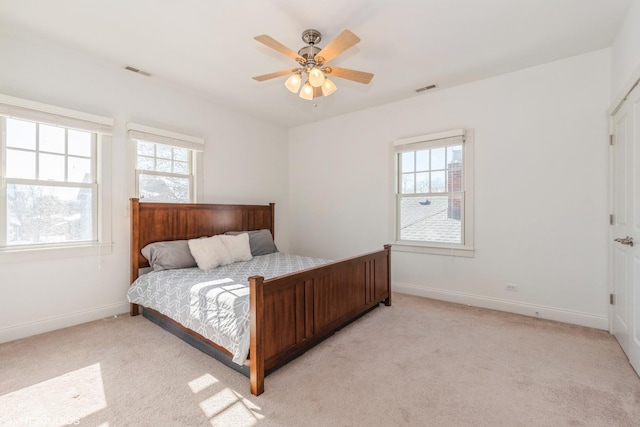 carpeted bedroom featuring multiple windows, visible vents, and baseboards