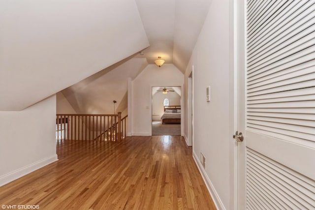 additional living space featuring visible vents, baseboards, lofted ceiling, light wood-style flooring, and ceiling fan