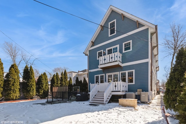 snow covered property with a balcony and central air condition unit