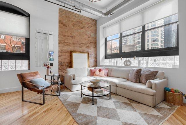 interior space featuring a healthy amount of sunlight, a towering ceiling, visible vents, and wood finished floors