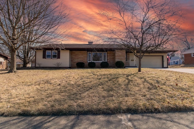 single story home featuring driveway, a chimney, and a yard