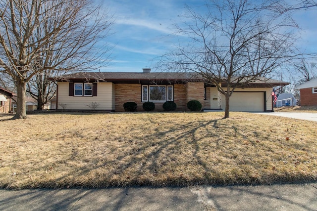 ranch-style house featuring an attached garage, a front lawn, and concrete driveway