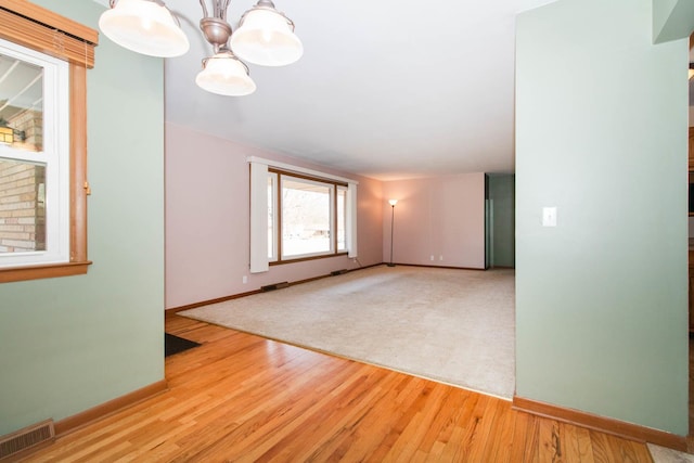 unfurnished room featuring visible vents, baseboards, and wood finished floors