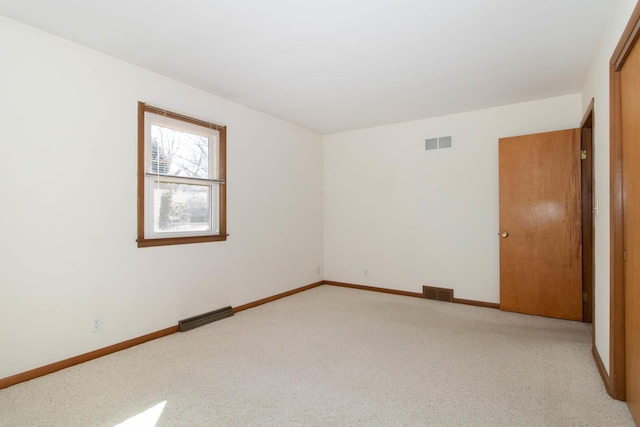 unfurnished room with light carpet, baseboards, and visible vents