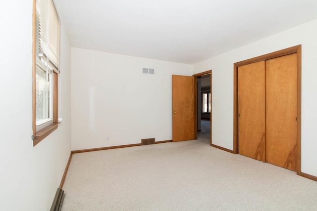 unfurnished bedroom with baseboards, carpet, visible vents, and a closet