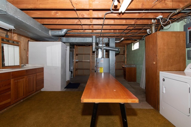 basement featuring water heater, washer / clothes dryer, and a sink