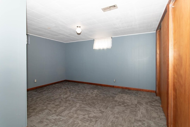 unfurnished room with carpet floors, visible vents, and baseboards