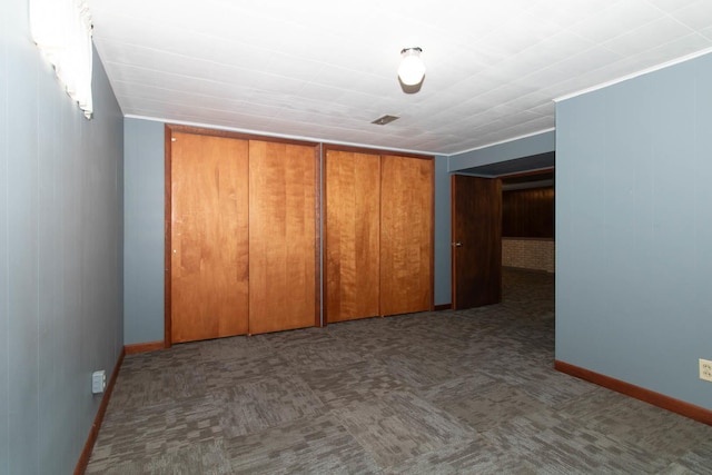 unfurnished bedroom with a closet, carpet, visible vents, and baseboards