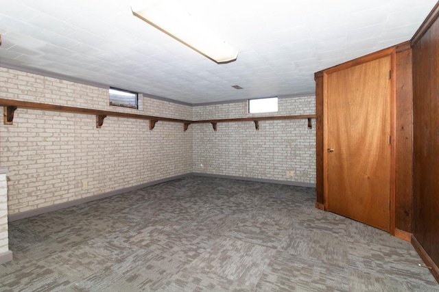 below grade area with brick wall and carpet flooring