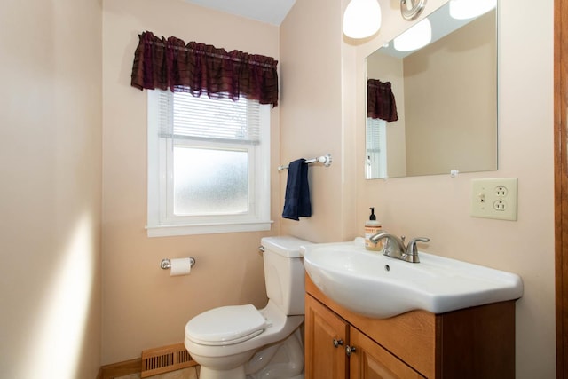 bathroom with visible vents, vanity, and toilet