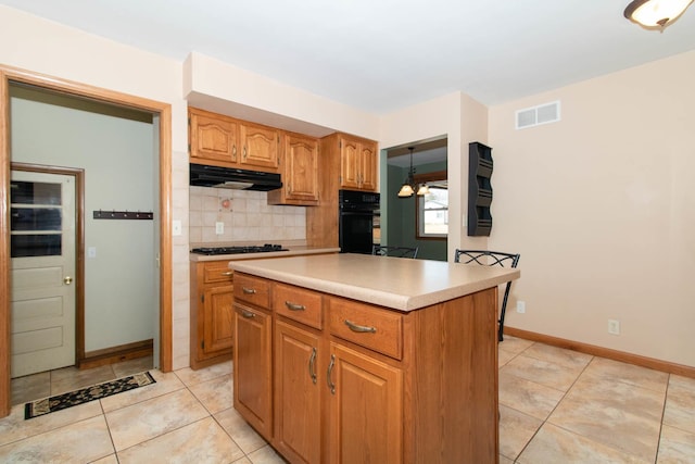 kitchen with light countertops, visible vents, backsplash, under cabinet range hood, and black appliances