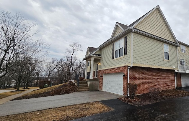 view of property exterior featuring brick siding, driveway, and an attached garage